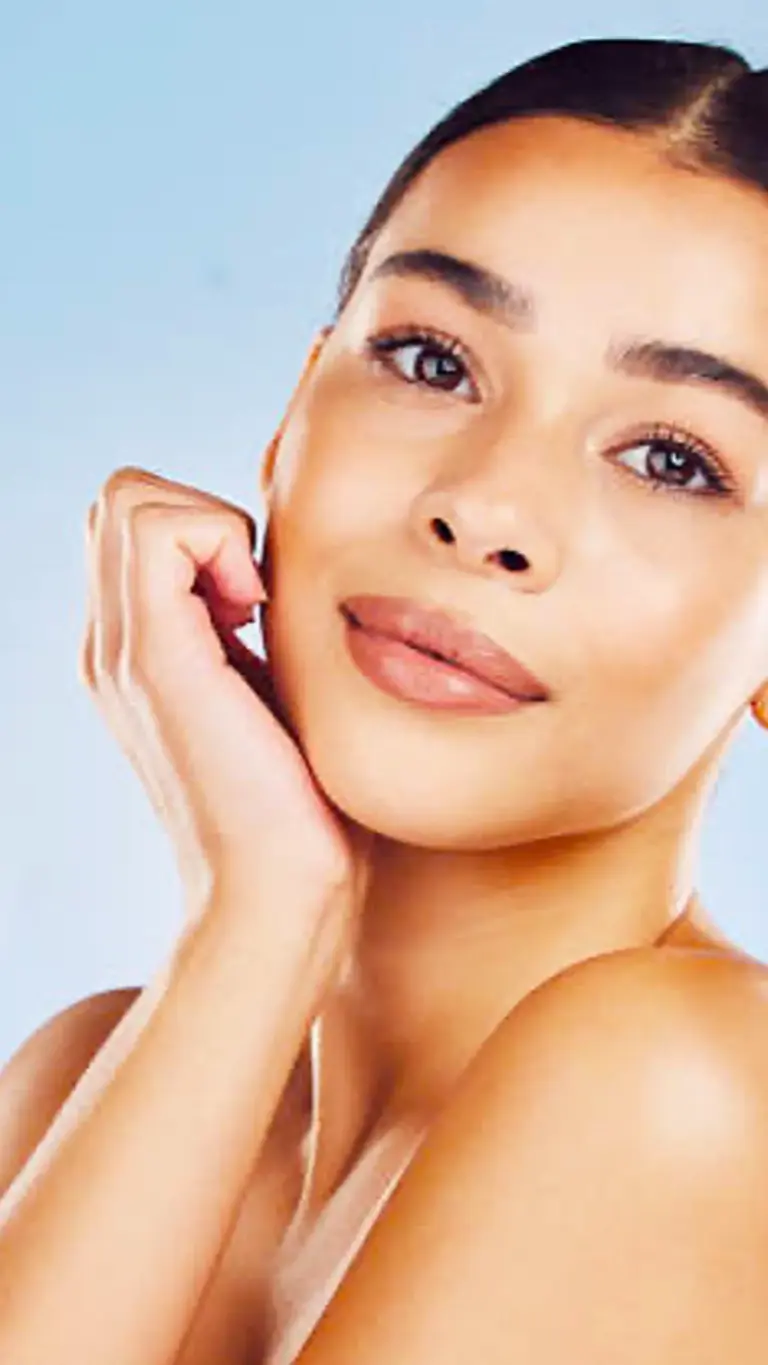 Woman with healthy, glowing skin touching her face